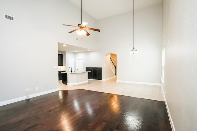 unfurnished living room featuring baseboards, a ceiling fan, and wood finished floors