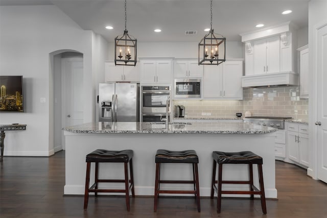 kitchen featuring stainless steel appliances, a kitchen island with sink, and white cabinets