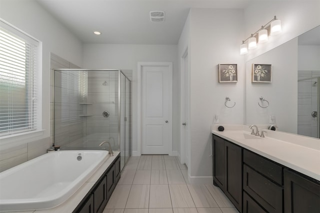 bathroom with visible vents, a shower stall, vanity, a tub, and baseboards