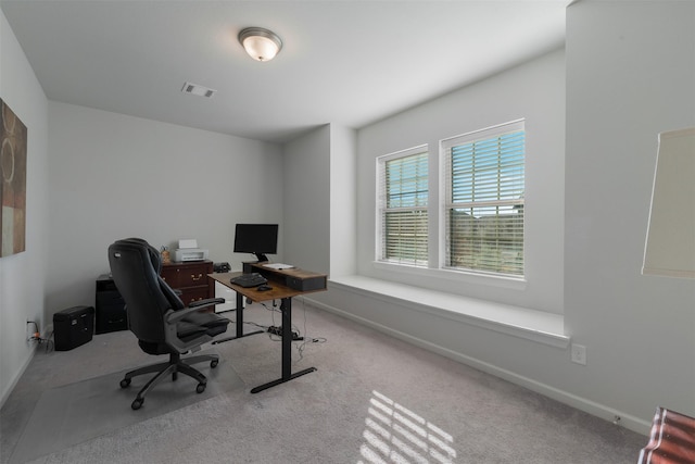 office space with baseboards, visible vents, and light colored carpet