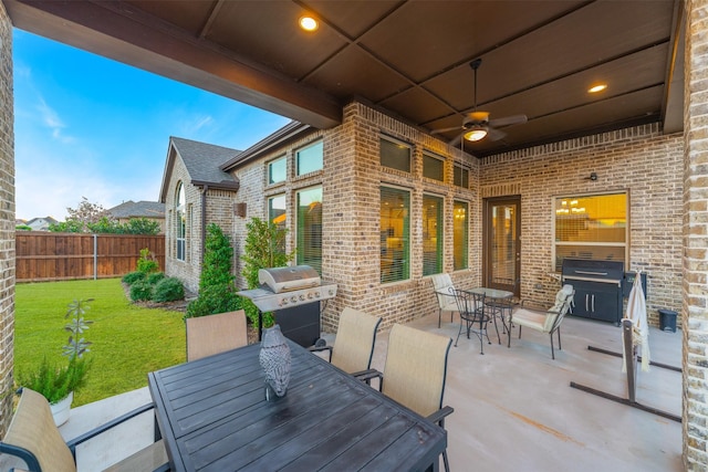 view of patio featuring ceiling fan, outdoor dining space, area for grilling, and fence