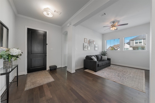 entrance foyer with crown molding, visible vents, dark wood finished floors, and arched walkways