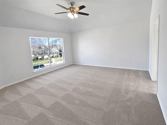 empty room with light colored carpet, vaulted ceiling, baseboards, and ceiling fan