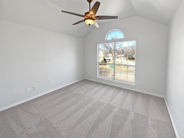 spare room featuring vaulted ceiling, carpet, a ceiling fan, and baseboards