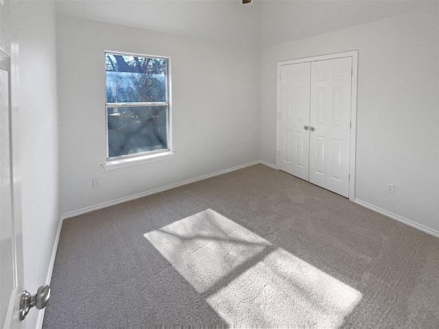 unfurnished bedroom with a closet, carpet flooring, and baseboards