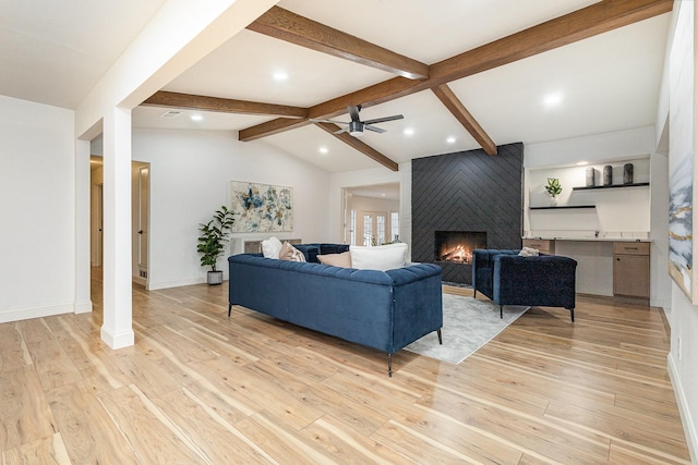 living room with baseboards, lofted ceiling with beams, light wood-style flooring, ceiling fan, and a fireplace