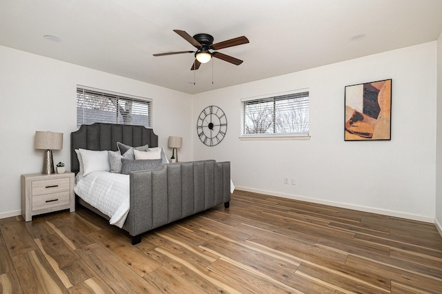 bedroom featuring dark wood-style flooring, multiple windows, and baseboards