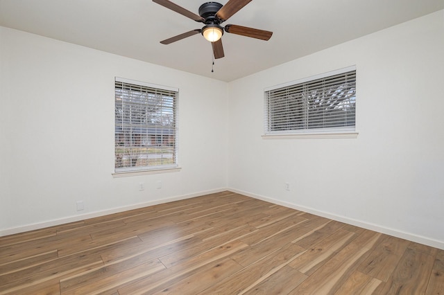 unfurnished room featuring a ceiling fan, baseboards, and wood finished floors