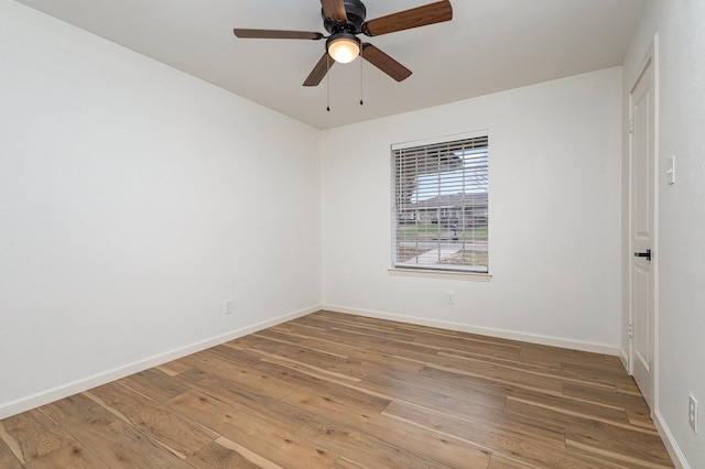 spare room with a ceiling fan, baseboards, and wood finished floors