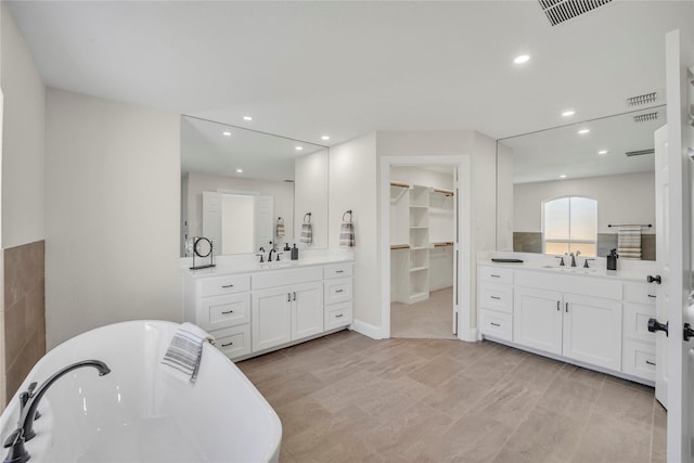 7004 Ledbetter Rd, Arlington, TX 76001 - full bathroom with two vanities, a freestanding tub, recessed lighting, and a spacious closet