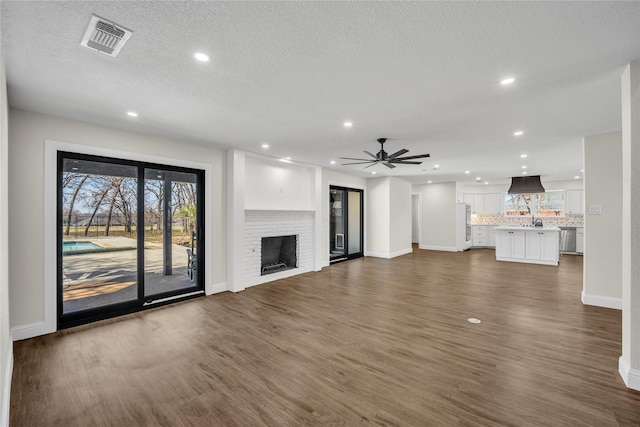 7004 Ledbetter Rd, Arlington, TX 76001 - unfurnished living room featuring dark wood-style flooring, baseboards, recessed lighting, a brick fireplace, and ceiling fan