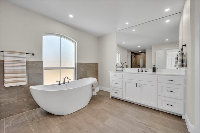 7004 Ledbetter Rd, Arlington, TX 76001 - full bathroom featuring tile walls, a shower stall, vanity, a freestanding bath, and recessed lighting