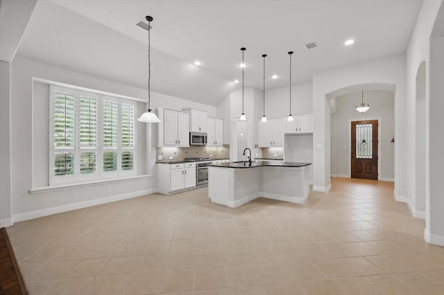 869 Field Xing, Little Elm, TX 76227 - kitchen with dark countertops, appliances with stainless steel finishes, light tile patterned floors, arched walkways, and recessed lighting