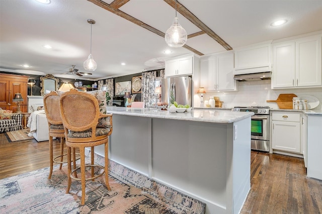 kitchen with open floor plan, stainless steel appliances, white cabinetry, and pendant lighting