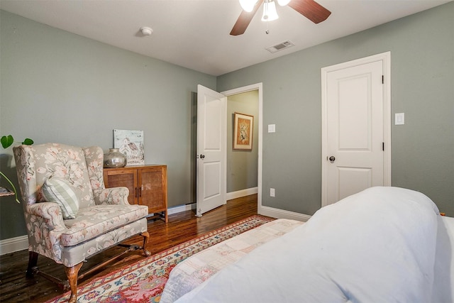 bedroom featuring a ceiling fan, visible vents, baseboards, and wood finished floors