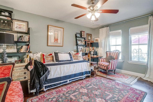 bedroom featuring a ceiling fan, baseboards, and wood finished floors