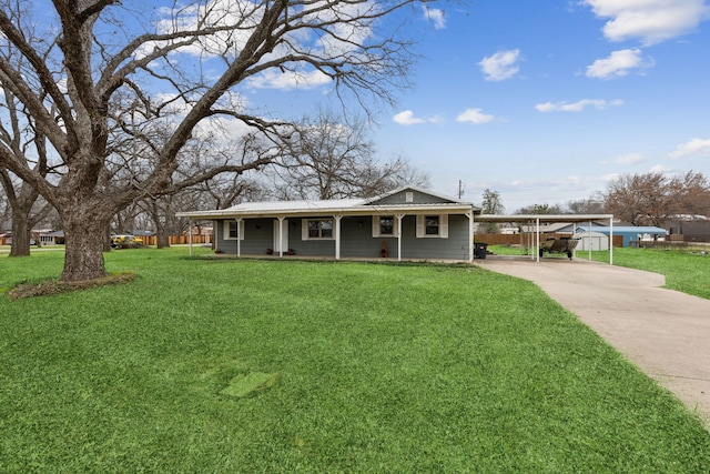 view of front of house with metal roof, a front lawn, a carport, and concrete driveway