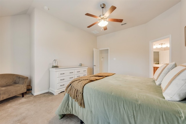 bedroom featuring ceiling fan, light colored carpet, visible vents, vaulted ceiling, and ensuite bath