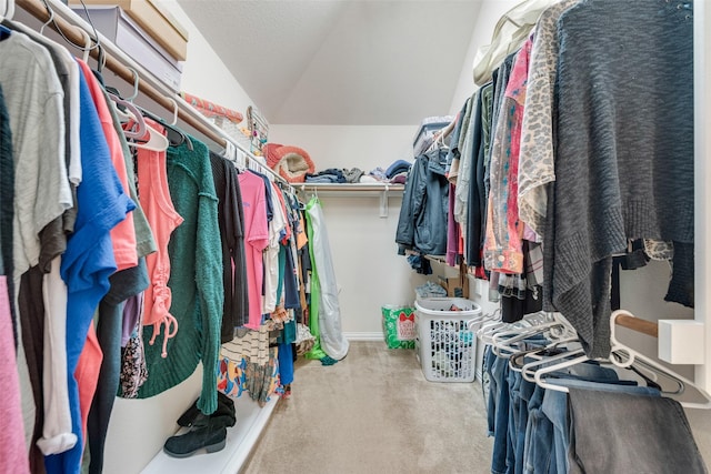 walk in closet with carpet and vaulted ceiling