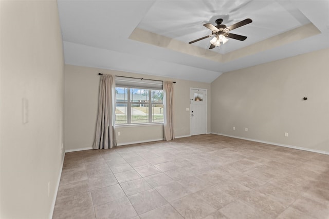 empty room with a tray ceiling, ceiling fan, baseboards, and light tile patterned floors