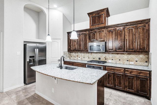 kitchen featuring a center island with sink, stainless steel appliances, a sink, and decorative light fixtures