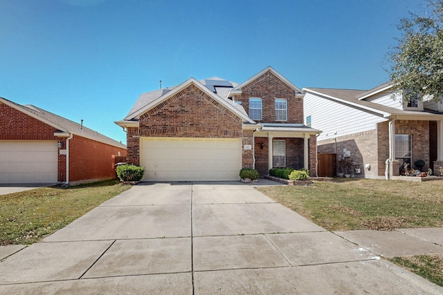 traditional-style house with solar panels, a front lawn, concrete driveway, a garage, and brick siding