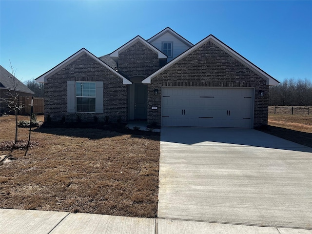 view of front of property with a garage, concrete driveway, and brick siding