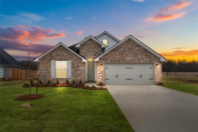 view of front facade featuring brick siding, concrete driveway, a lawn, fence, and a garage