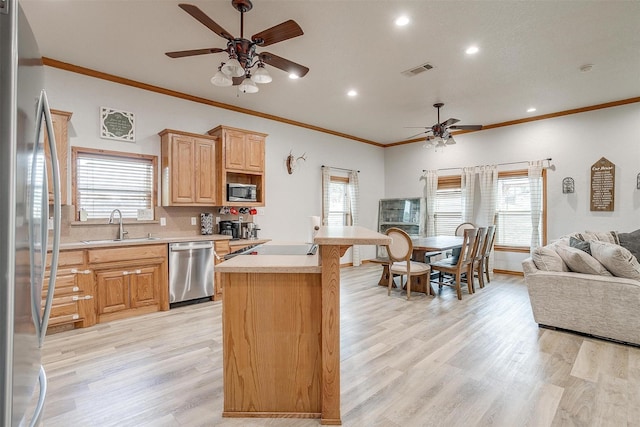 kitchen with visible vents, appliances with stainless steel finishes, open floor plan, light countertops, and a sink