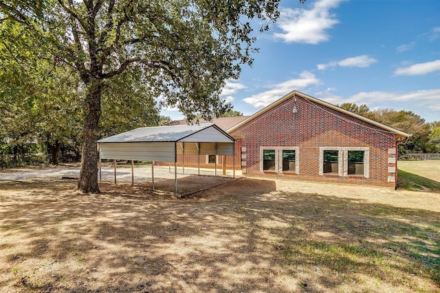 view of front of property featuring a front yard, a carport, and brick siding