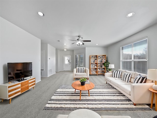 living room featuring light carpet, visible vents, a ceiling fan, and recessed lighting