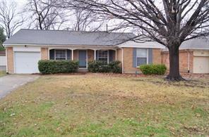 ranch-style house with driveway, a garage, and a front yard