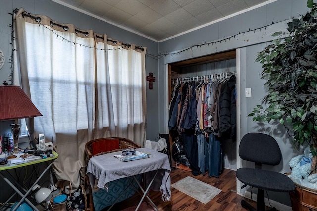 bedroom with a closet, crown molding, and wood finished floors