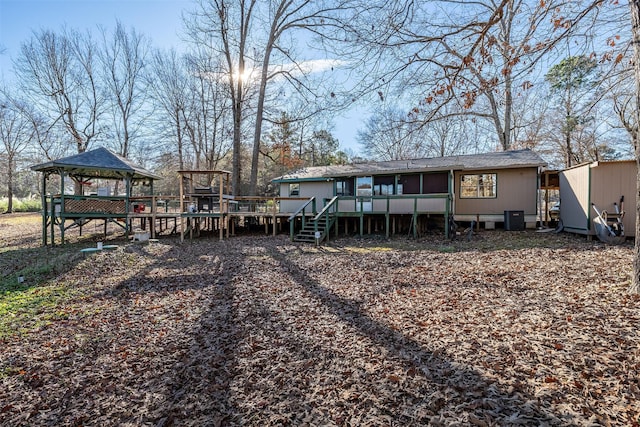 rear view of house featuring a wooden deck, a gazebo, and central AC unit