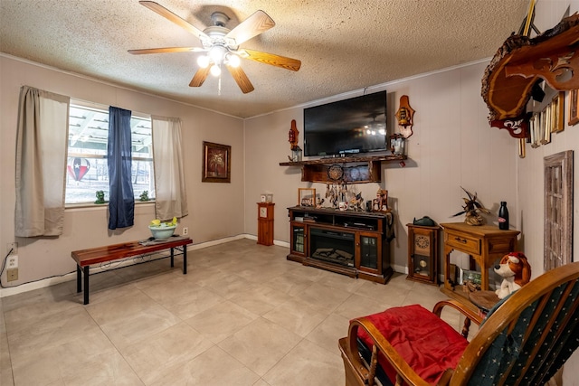 living room featuring a ceiling fan, a fireplace, a textured ceiling, and light tile patterned floors