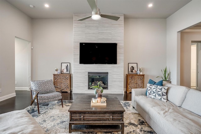 living room featuring baseboards, a ceiling fan, dark wood-style floors, a fireplace, and recessed lighting