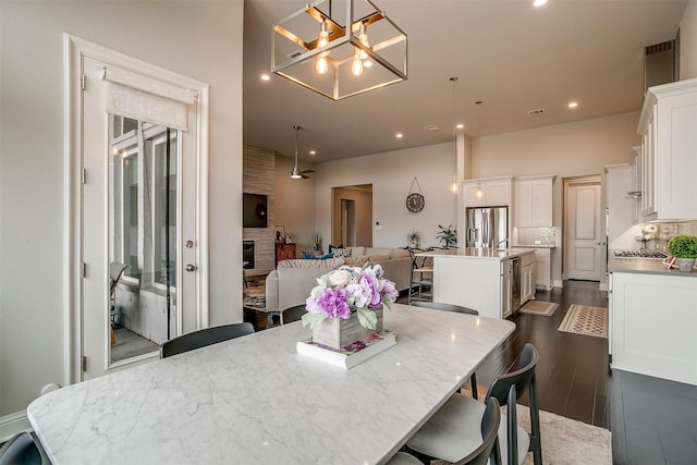 dining space with a notable chandelier, recessed lighting, dark wood-type flooring, a fireplace, and visible vents