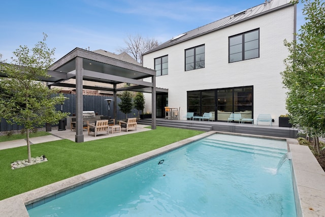 rear view of property with a lawn, metal roof, a standing seam roof, fence, and an outdoor living space