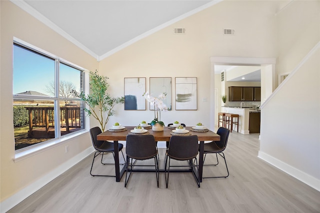 dining area with light wood-style floors, visible vents, and ornamental molding