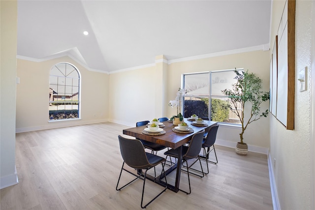 dining area with baseboards, ornamental molding, and light wood-style flooring