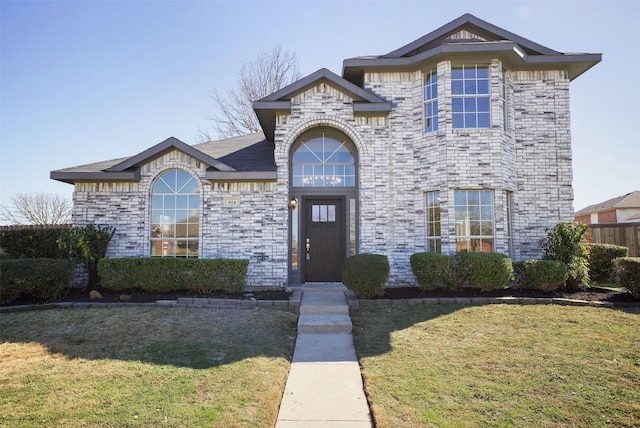 view of front facade with a front yard and brick siding