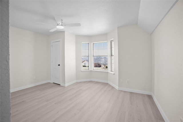 unfurnished room with light wood-type flooring, ceiling fan, a textured ceiling, and baseboards