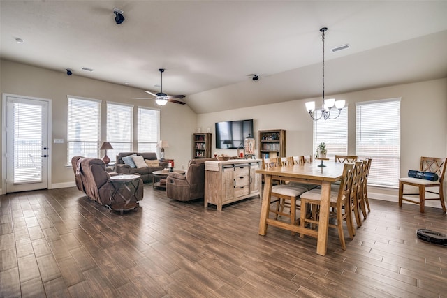 dining space featuring visible vents, dark wood-type flooring, ceiling fan with notable chandelier, baseboards, and lofted ceiling