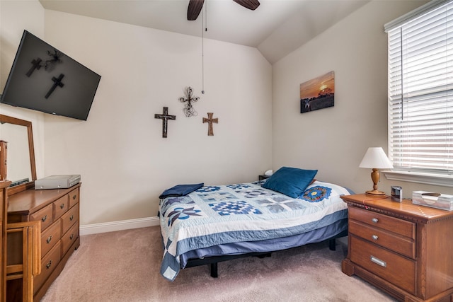 bedroom featuring baseboards, light carpet, lofted ceiling, and ceiling fan