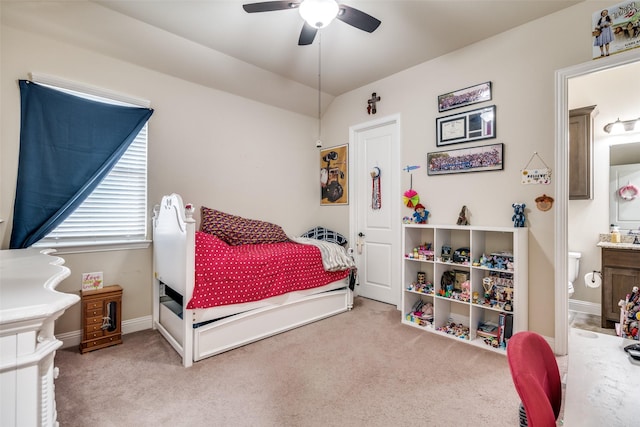 bedroom with baseboards, ceiling fan, vaulted ceiling, carpet flooring, and ensuite bath