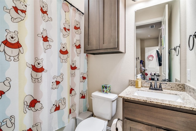 bathroom with vanity, toilet, and visible vents