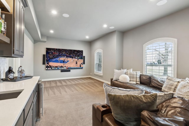 living area with recessed lighting, light colored carpet, and baseboards