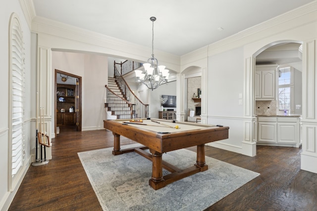 rec room with crown molding, dark wood-style flooring, and a chandelier