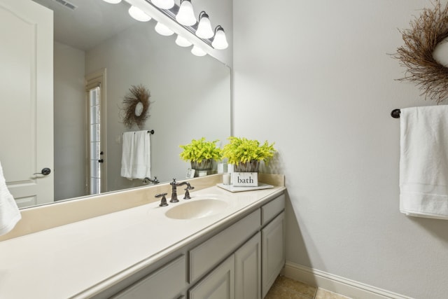 bathroom with vanity, visible vents, baseboards, and tile patterned flooring