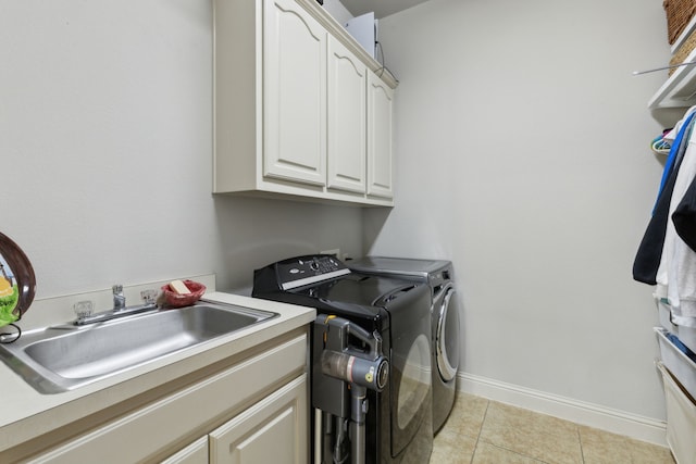 laundry room with baseboards, washing machine and dryer, light tile patterned floors, cabinet space, and a sink